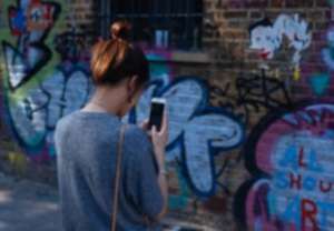 Girl taking a photo of an art wall