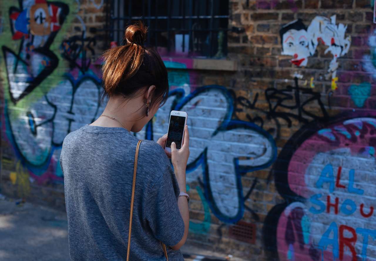 Girl taking a photo of an art wall Girl taking a photo of an art wall