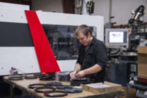 Operator monitoring and assembling ABS parts at a Milacron Injection Molding machine at SEA-LECT Plastics Corporation.