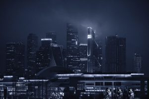 Dramatic night view of modern skyscrapers under a foggy sky