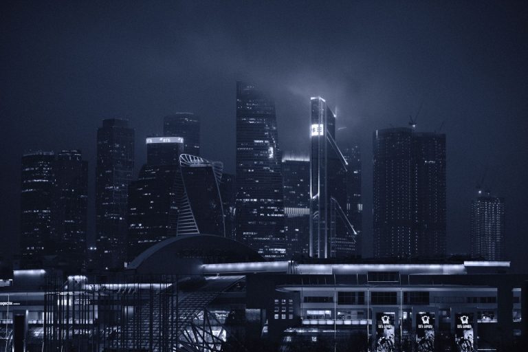 Dramatic night view of modern skyscrapers under a foggy sky