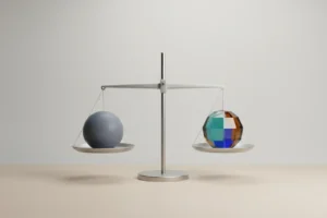 Minimal balance scale with a gray sphere and a multicolored sphere in perfect equilibrium on a soft neutral background.