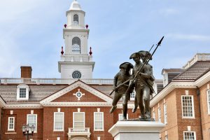 Delaware Legislative Hall in Dover behind a Revolutionary War monument