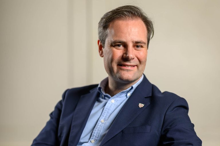 BitMEX cofounder Ben Delo seated in a dark jacket