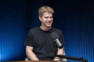 Factory CEO Matan Grinberg seated beside a microphone