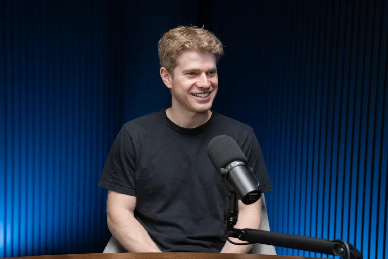 Factory CEO Matan Grinberg seated beside a microphone