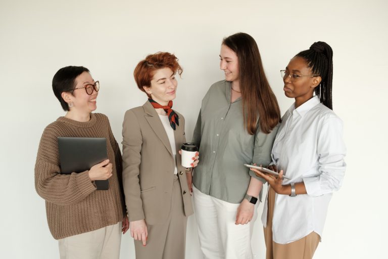 A diverse group of businesswomen engaging in a casual conversation indoors