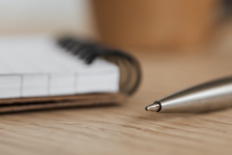 Silver pen beside an open notebook