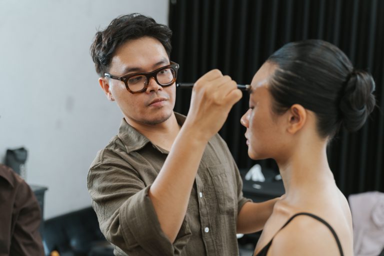 Makeup artist applying makeup to a model, as celebrated in Cholo Egiye Jai