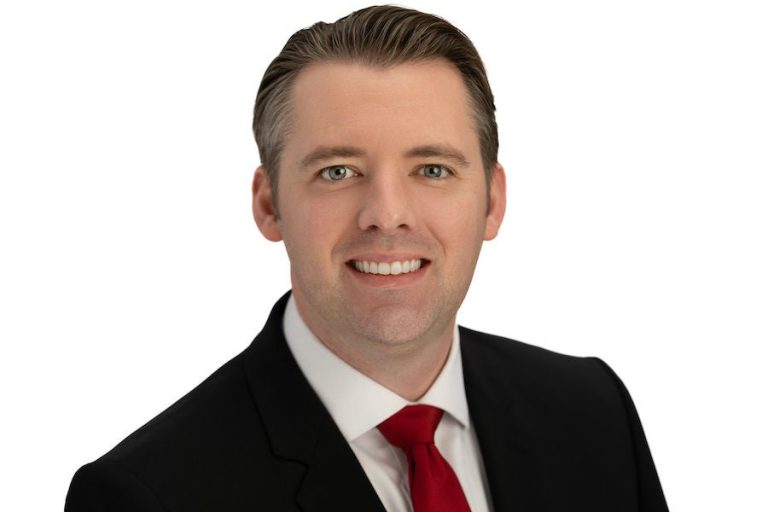 Chris Degnan in a suit and red tie