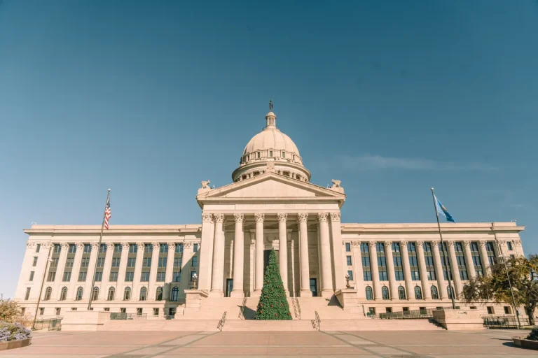 Front view of Oklahoma State Capitol adorned with a Christmas tree, under clear skies