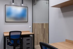 An office workspace with wooden desks and chairs