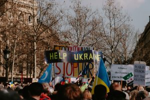 A large crowd holding signs advocating for Ukraine during a daytime protest