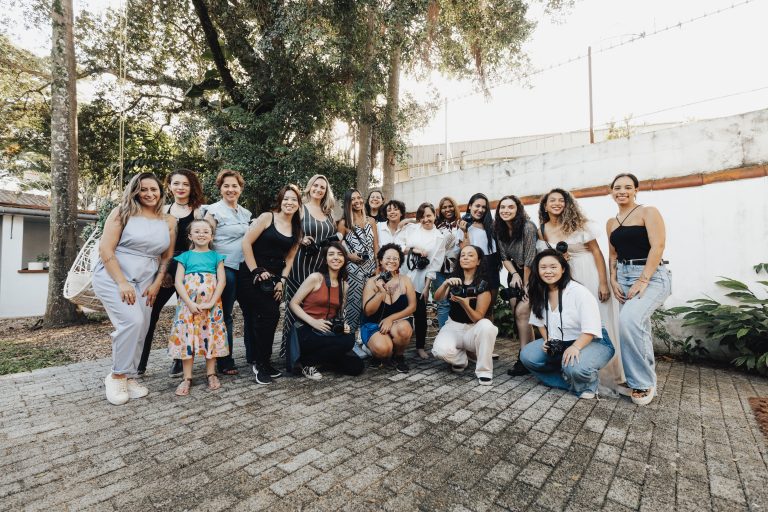 A cheerful group of diverse women and a child posing together outdoors on a sunny day